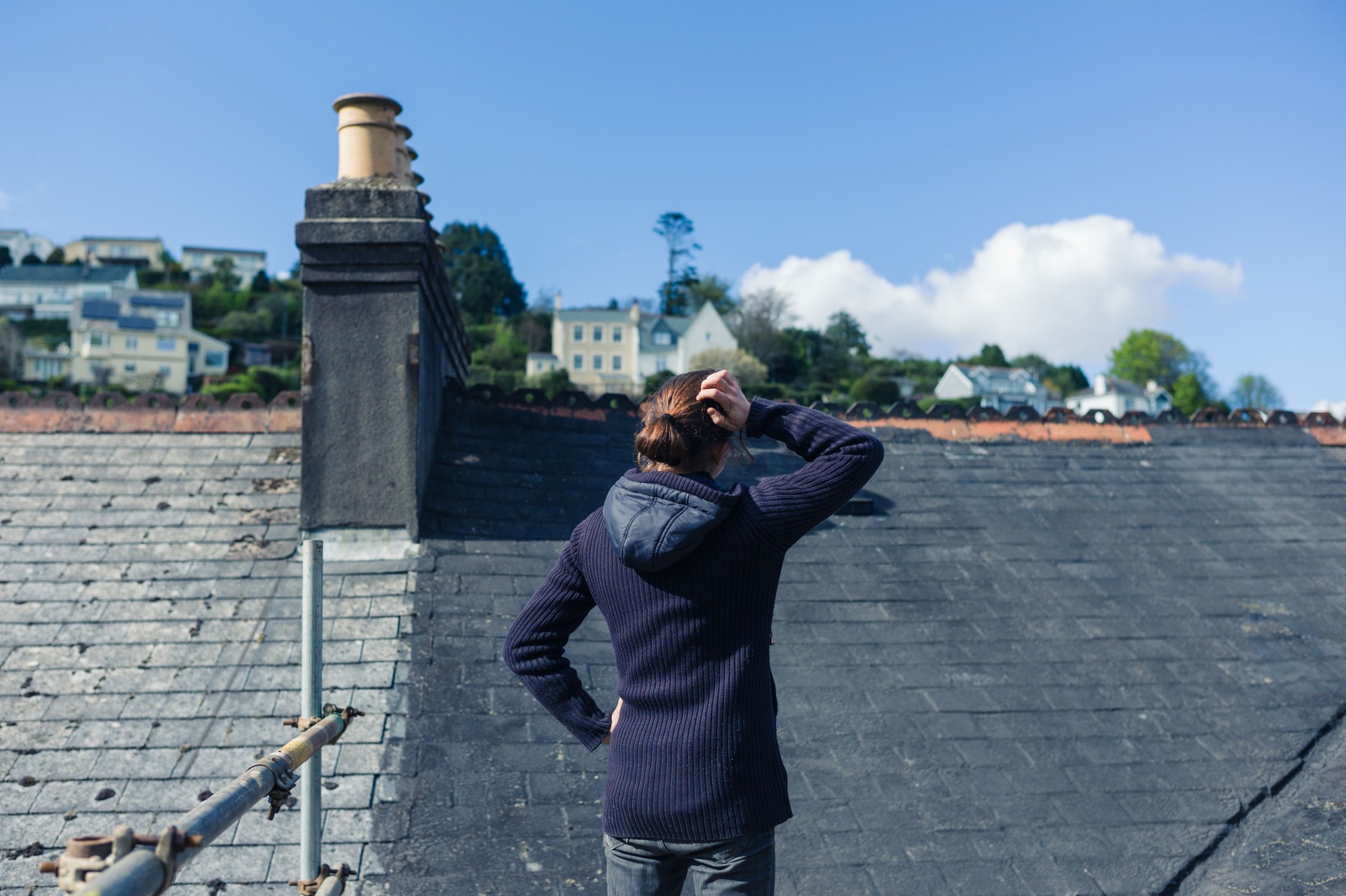 Young woman on scaffolding by roof